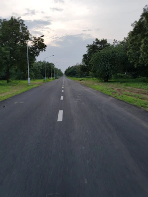 Wide concrete road lined with street lights inside Nagaraju Farm Land.