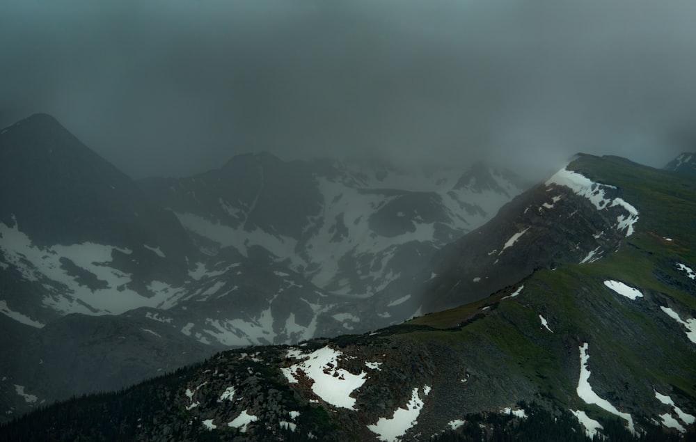 moss and snow covered mountains surrounded by fog