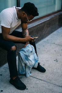 man sitting while using phone