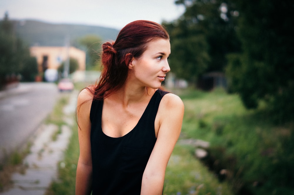 Tiefenschärfefotografie einer Frau im schwarzen Tanktop auf der Straße