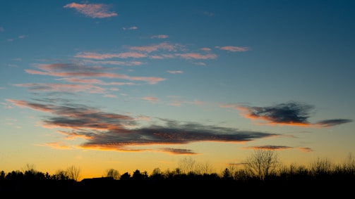 A peaceful sunset sky with soft clouds, symbolizing the 'piri hemel' where Saucijs now rests.