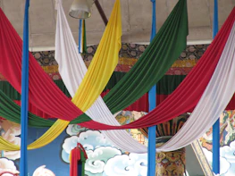 Wide shot of a themed event space featuring colorful textiles and decorative panels.