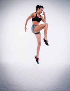 woman jumping near white wall paint