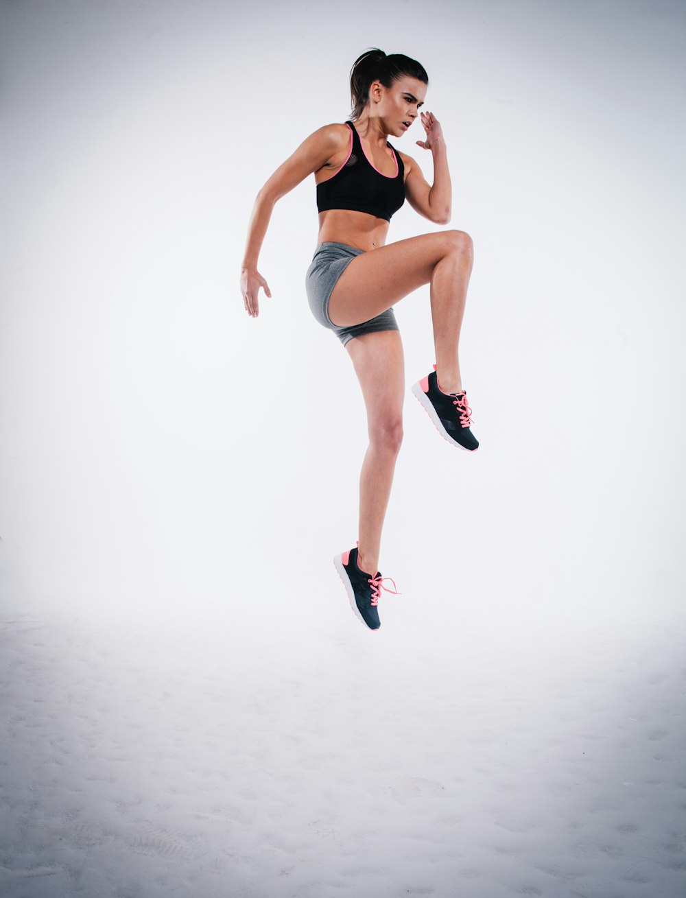 woman jumping near white wall paint