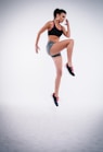 woman jumping near white wall paint