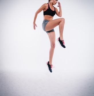 woman jumping near white wall paint