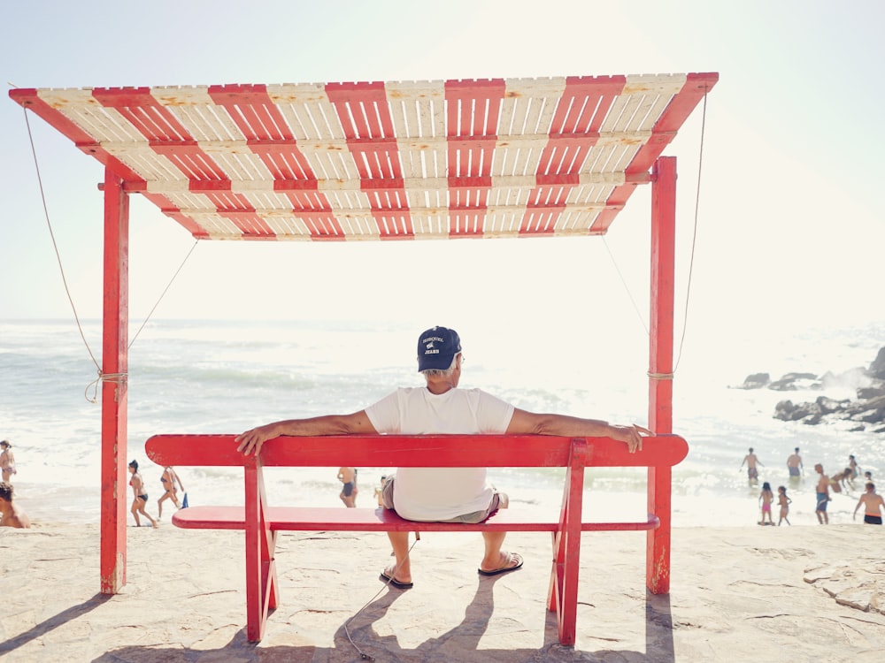 homem sentado no banco perto da praia