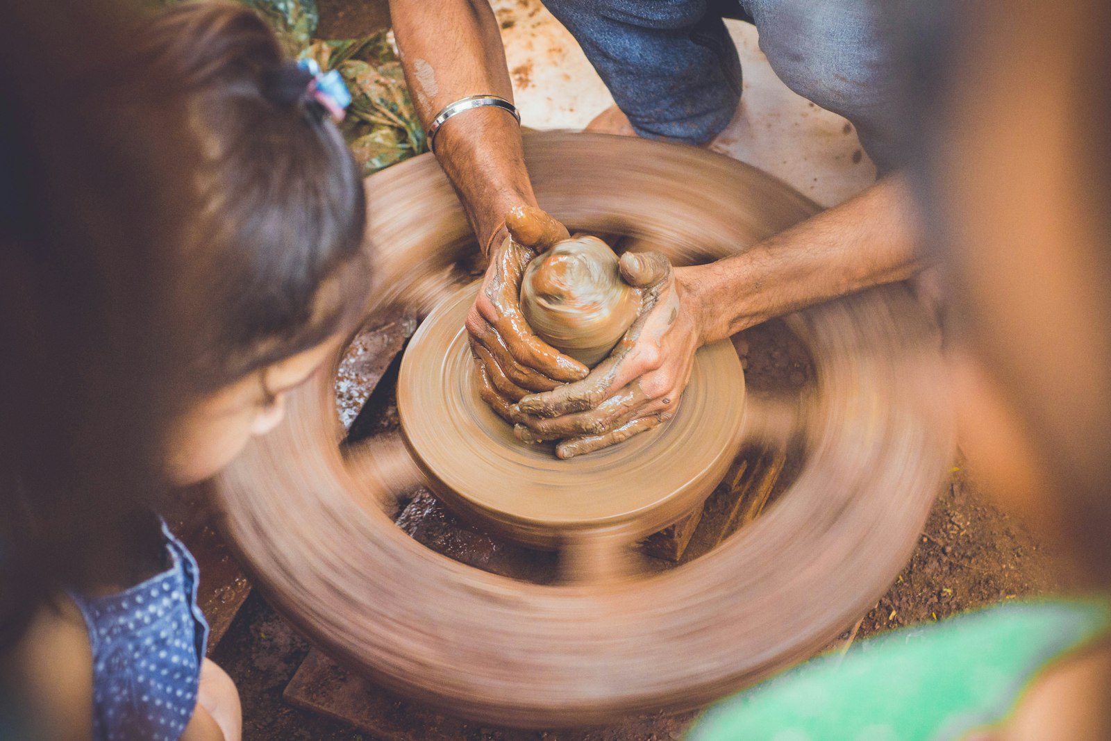 Nikon D3100 + Nikon AF Nikkor 50mm F1.8D sample photo. Person molding clay while photography