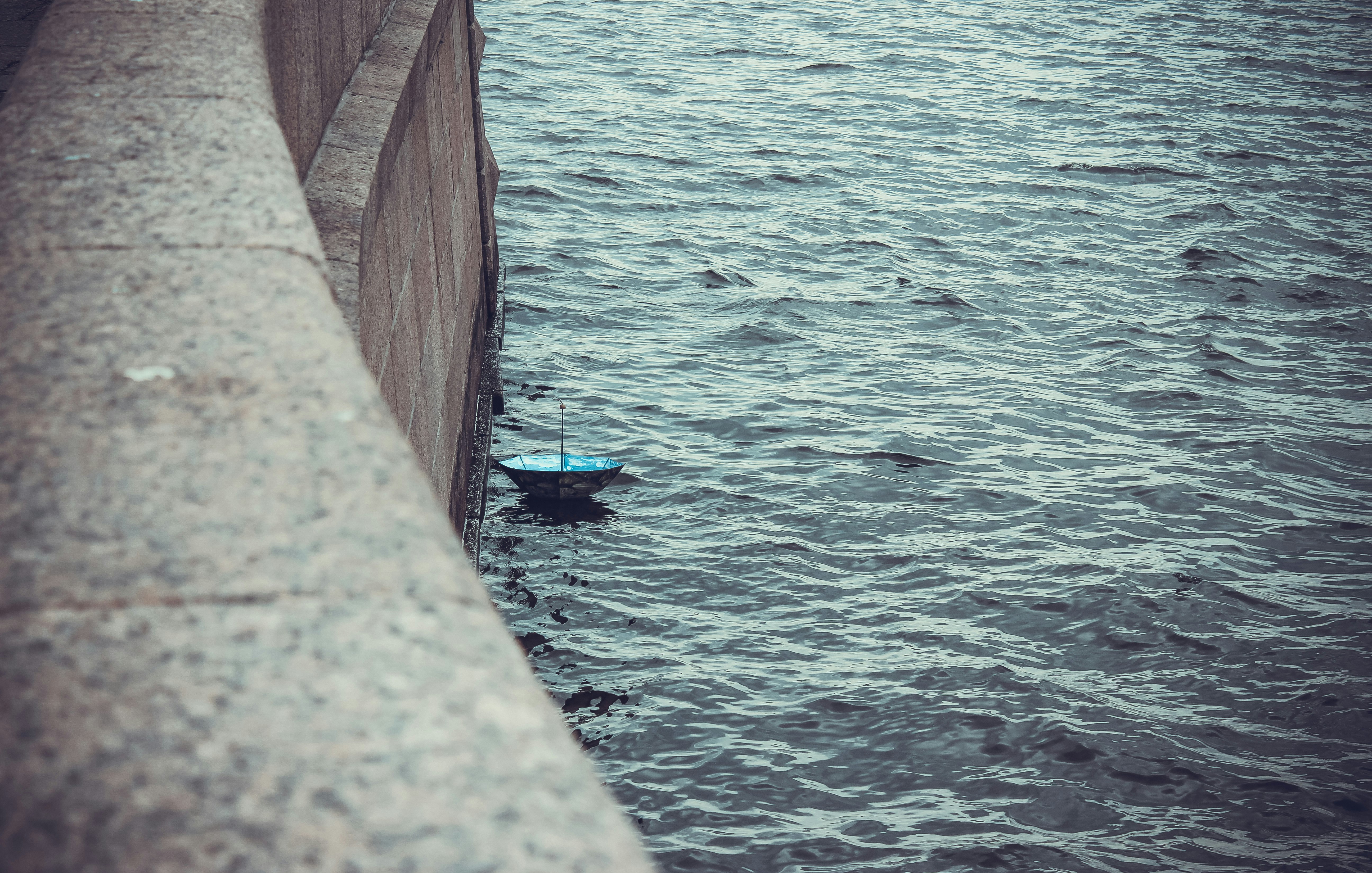 blue umbrella on body of water