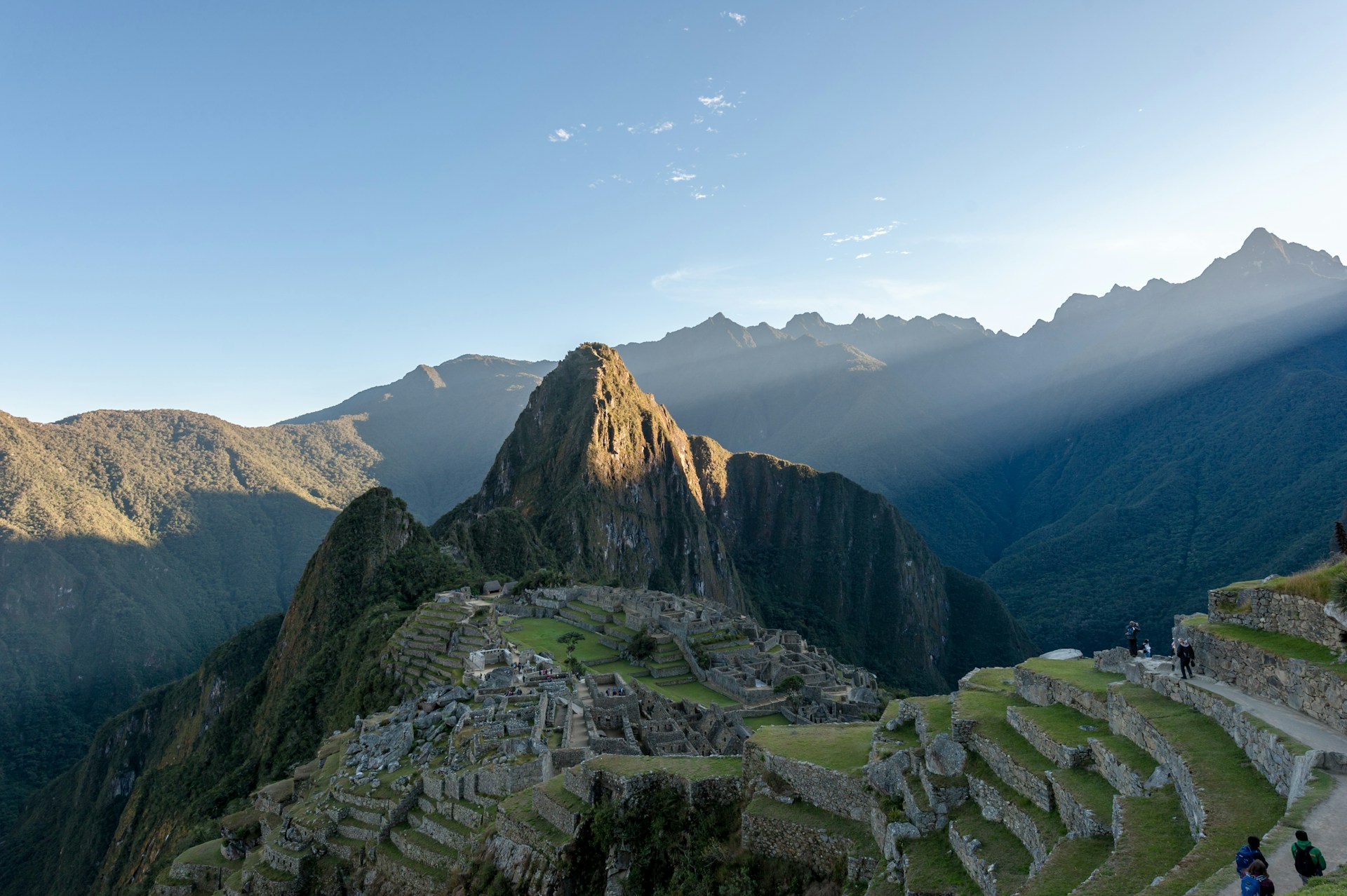 A vibrant photo of Machu Picchu at sunrise with warm golden light illuminating the ancient ruins.
