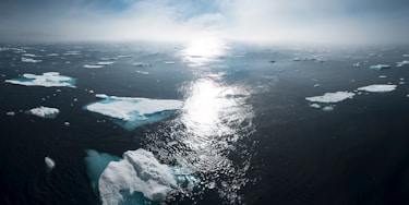 landscape and aerial photography of icebergs on body of water during daytime