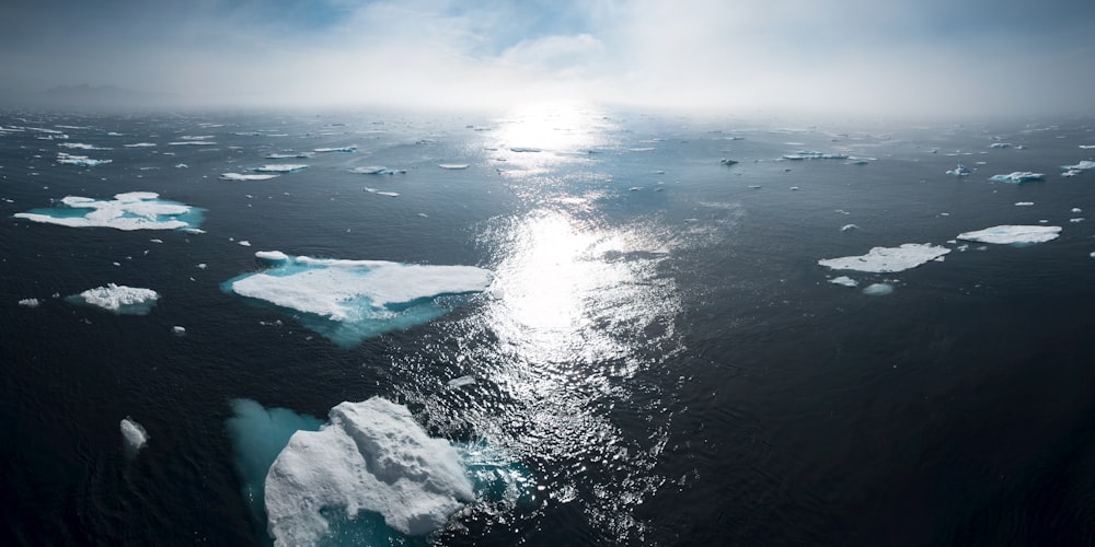 Landschafts- und Luftaufnahmen von Eisbergen auf Gewässern bei Tag