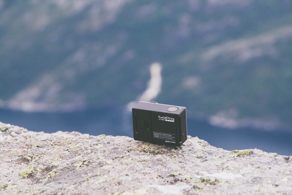 A GoPro camera sitting on a mountain cliff.