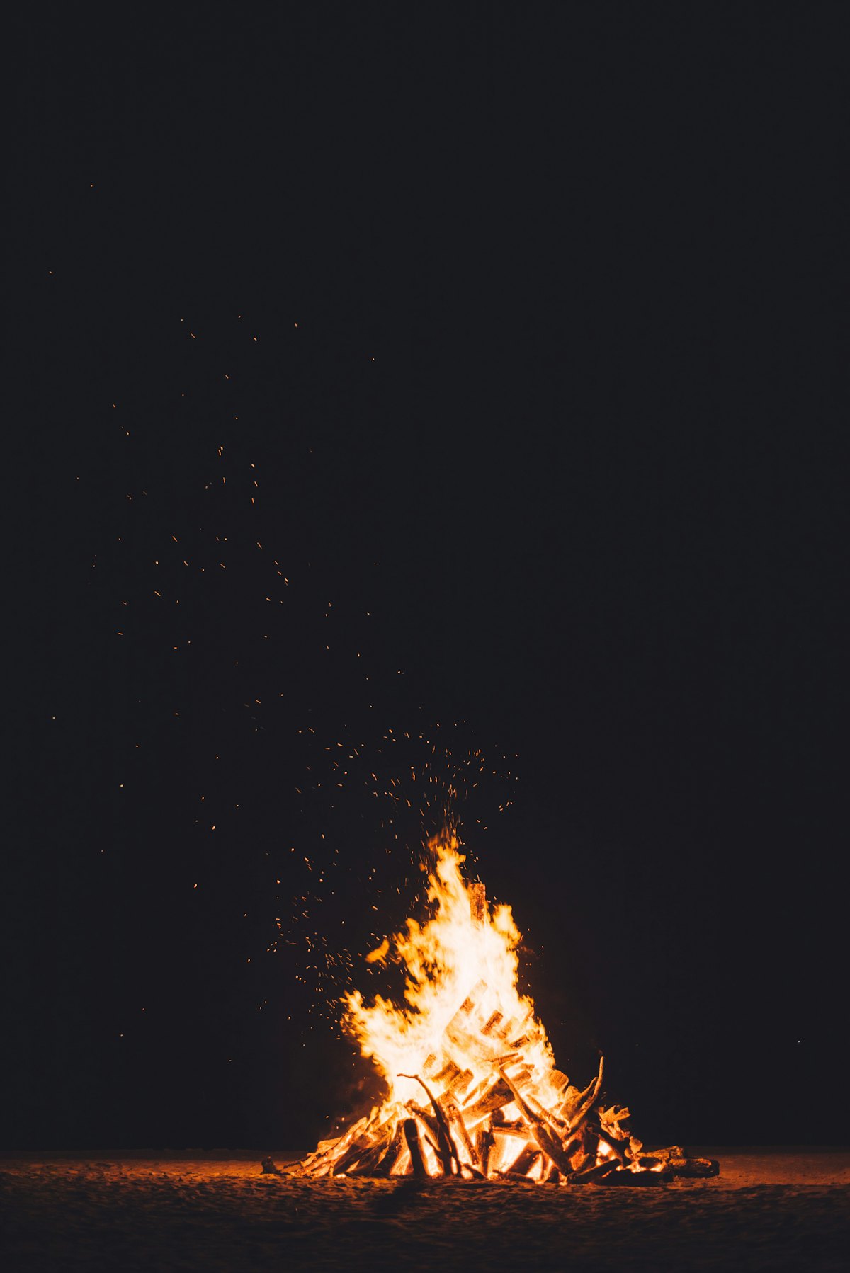 Roaring bonfire flames against darkness
