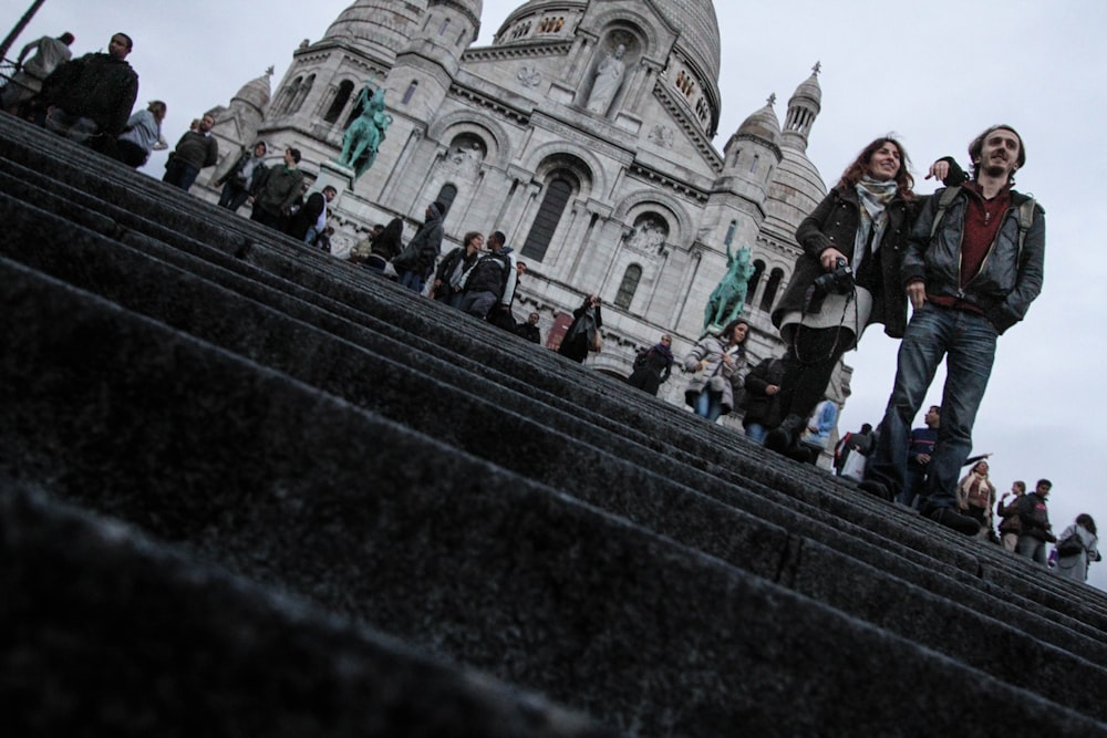 A couple standing in front of a historic French building.