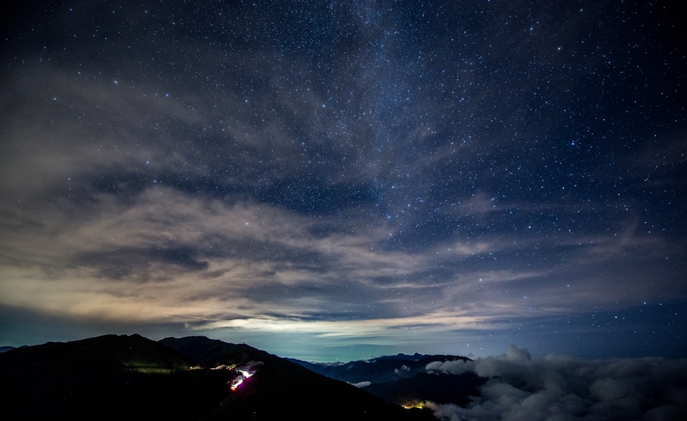 silueta de la montaña bajo las nubes blancas y grises foto