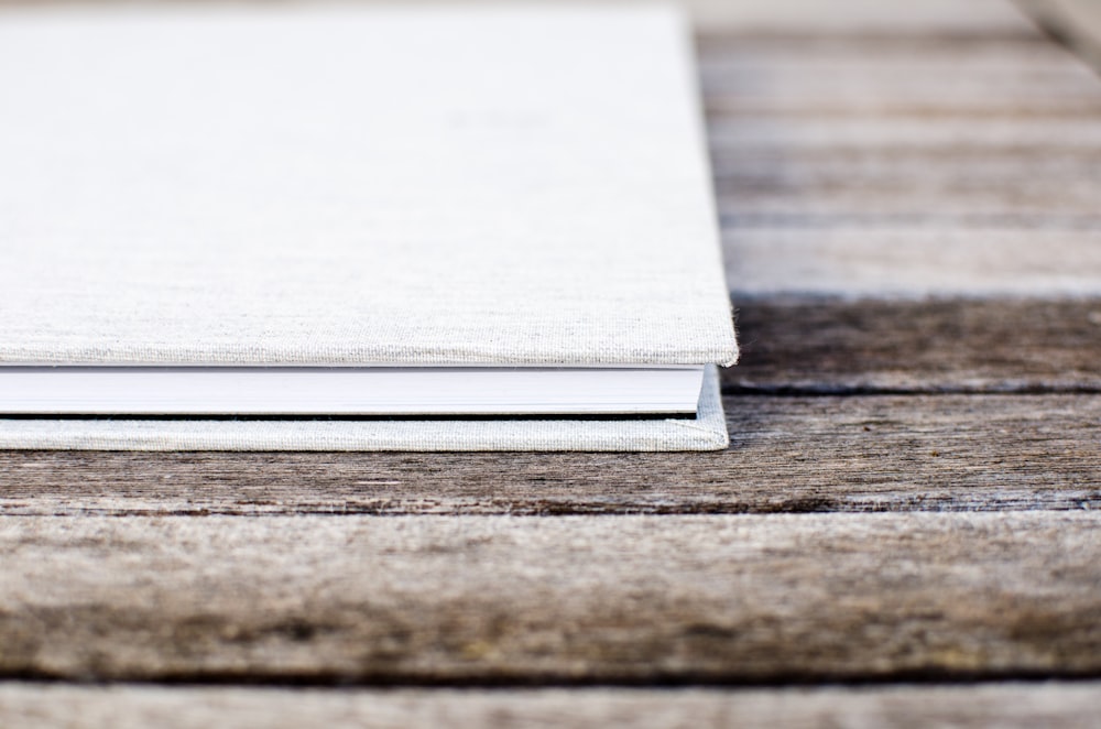 Libro bianco con copertina rigida seduto sul tavolo di legno