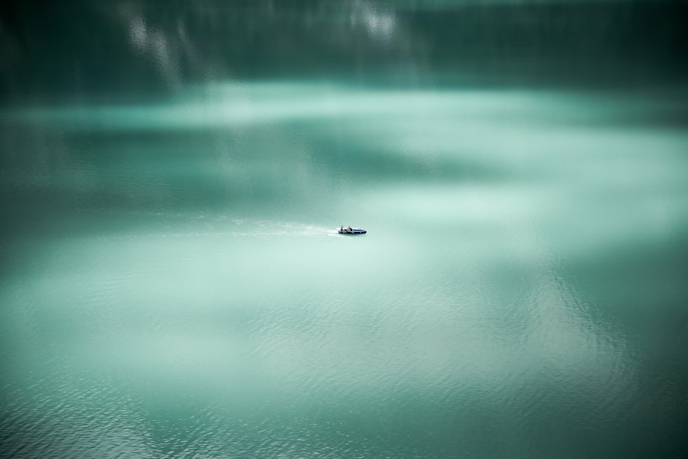 A drone shot of people paddling through the water at Oeschinen Lake