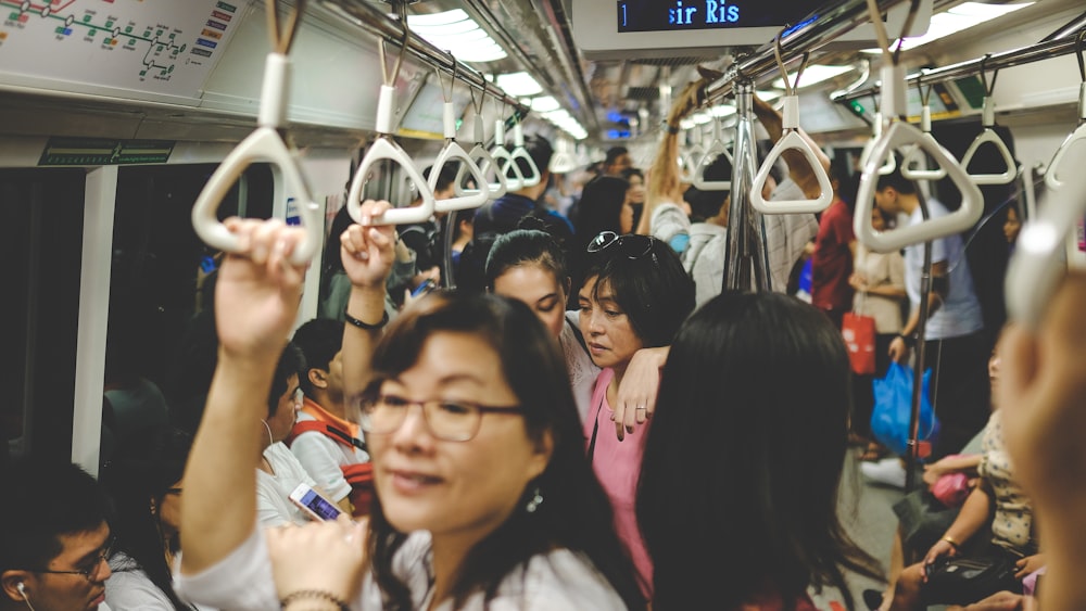 電車の中に立つピンクのTシャツを着た女性