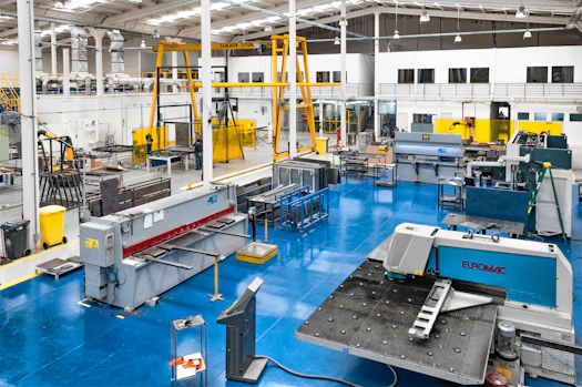 A dynamic industrial workspace with technicians collaborating over machinery and equipment.