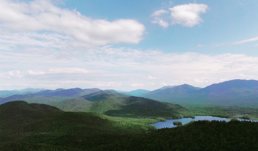 montagnes vertes sous des nuages blancs pendant la journée