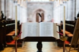 A warmly lit pulpit with an open Bible and a vintage microphone ready for preaching.