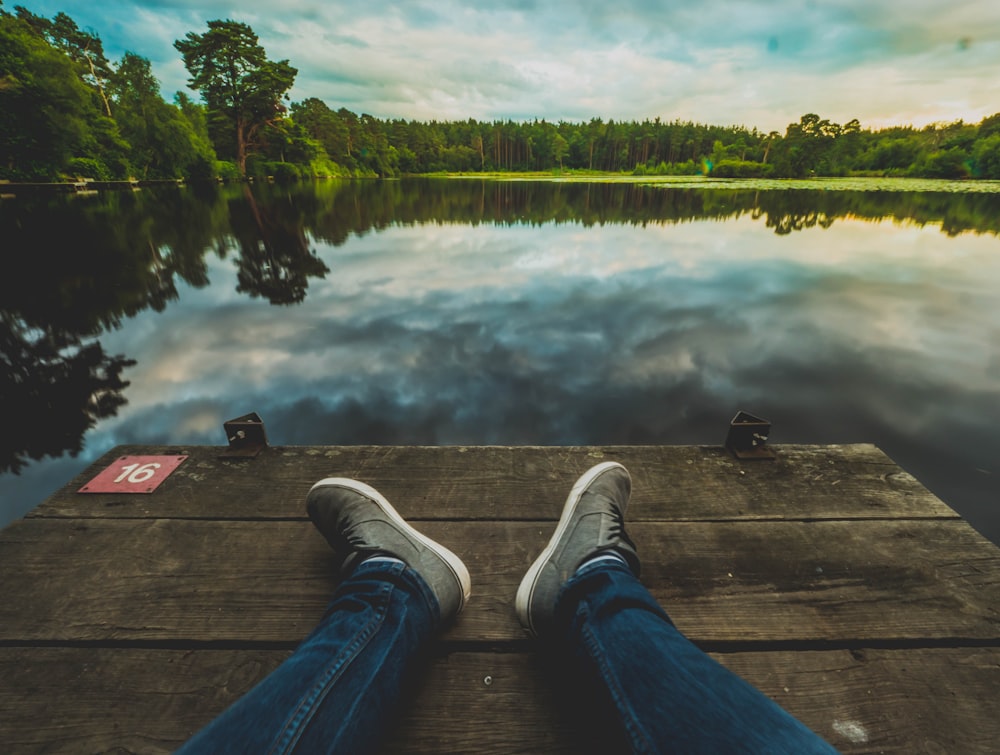 pair of gray-and-white sneakers and blue denim jeans