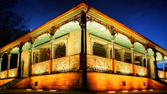 A beautifully carved wooden gazebo made by 369meubel.com, glowing warmly under evening light.