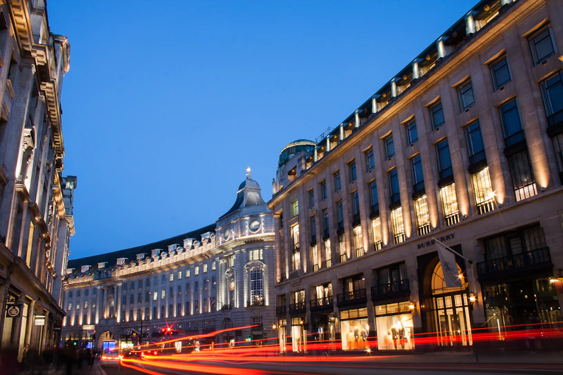 A cinematic photo capturing a bustling city street at dusk with warm glowing lights.