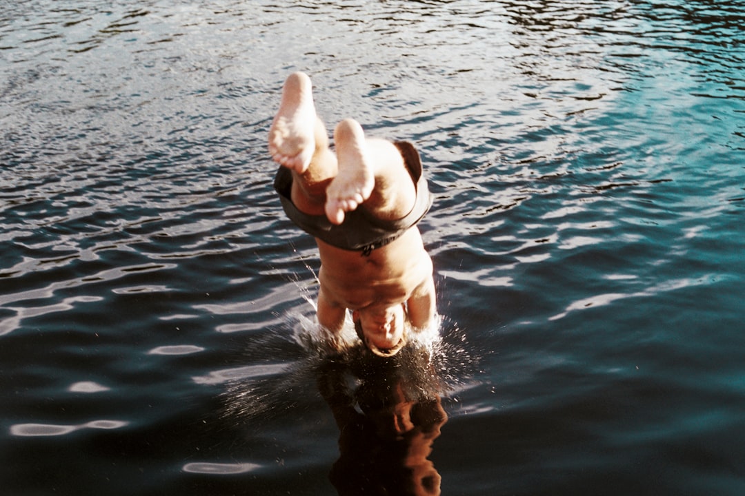 timelapse photography of man diving on water