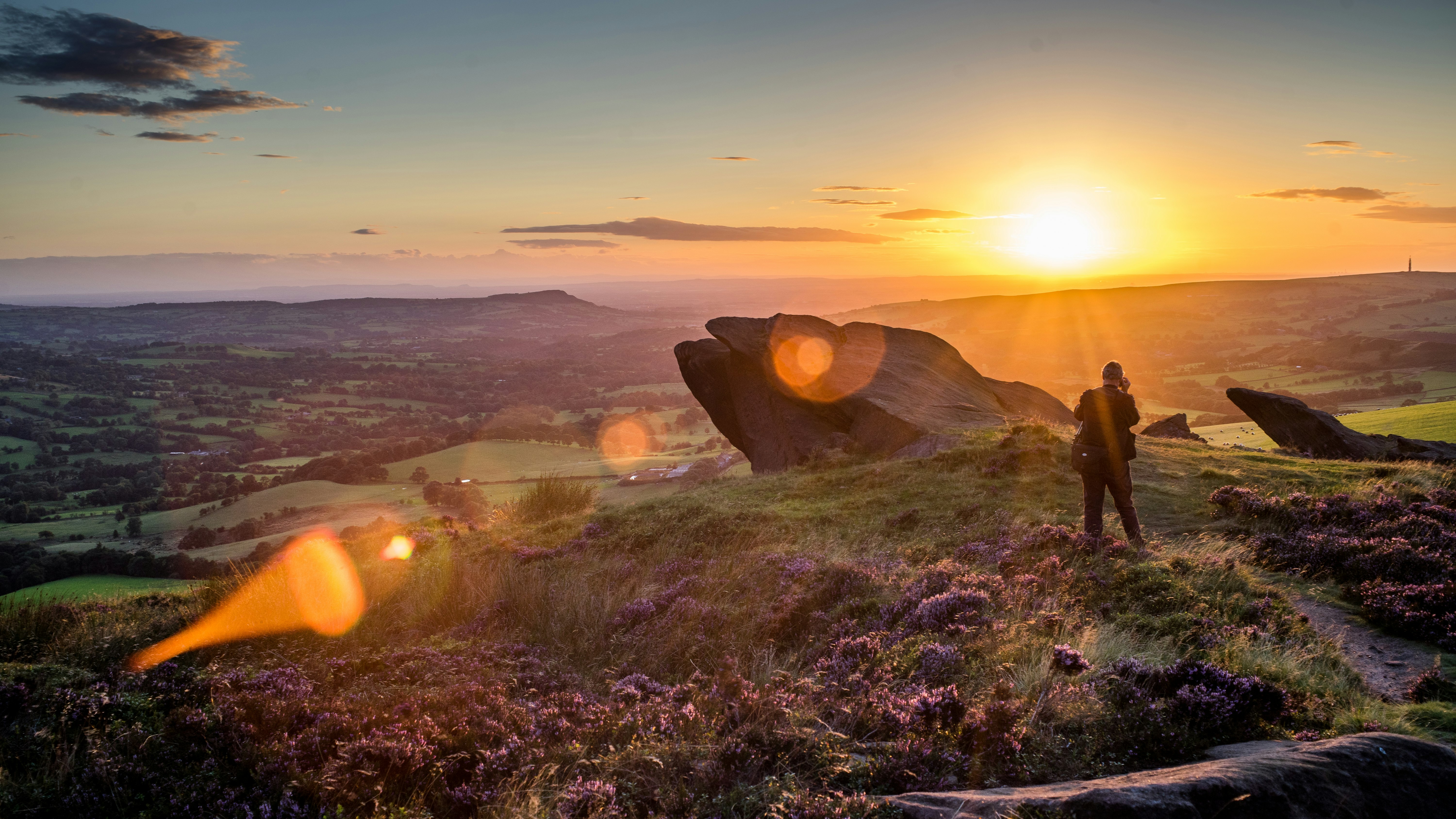 person standing near rock formation during sunset