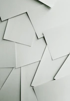 Scattered sheets of white paper covering the entire frame