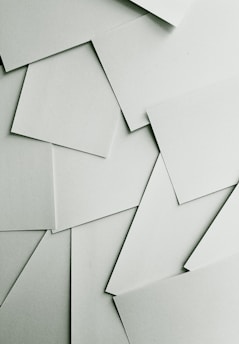 Scattered sheets of white paper covering the entire frame
