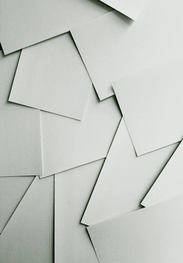 Scattered sheets of white paper covering the entire frame