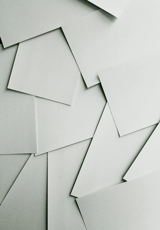 Scattered sheets of white paper covering the entire frame