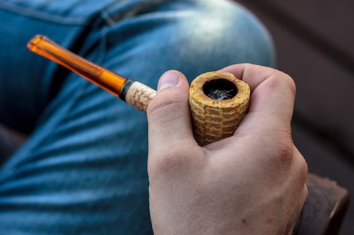 Hand holding a sleek, modern pipe with a matte black finish.