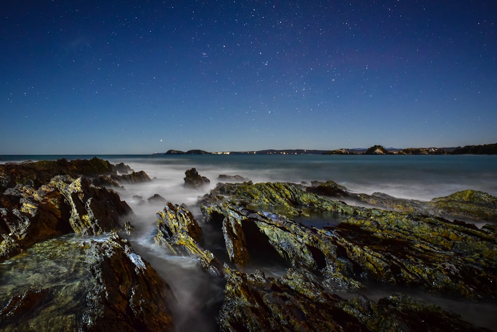 body of water and rocks under clear blue sky