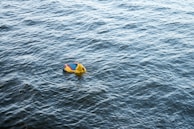 Close-up of a small child laughing while sitting on a bright blue water float.