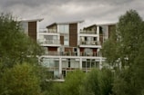 Exterior of an energy-efficient apartment building surrounded by trees.
