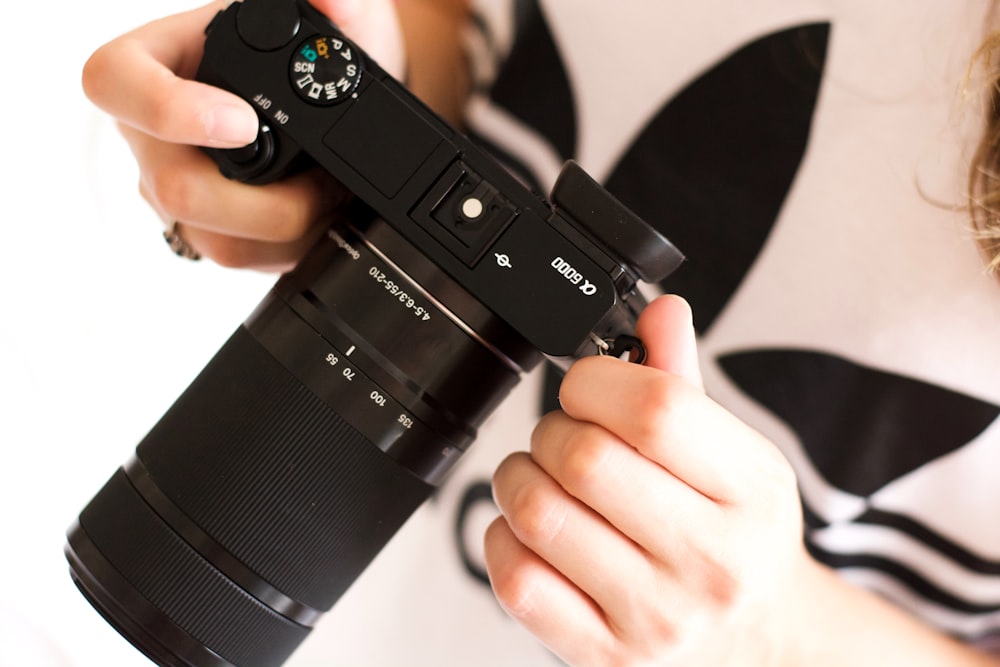 person holding black DSLR camera