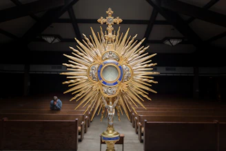 gold-colored cross table decor on top of brown wooden table