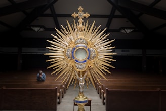 gold-colored cross table decor on top of brown wooden table