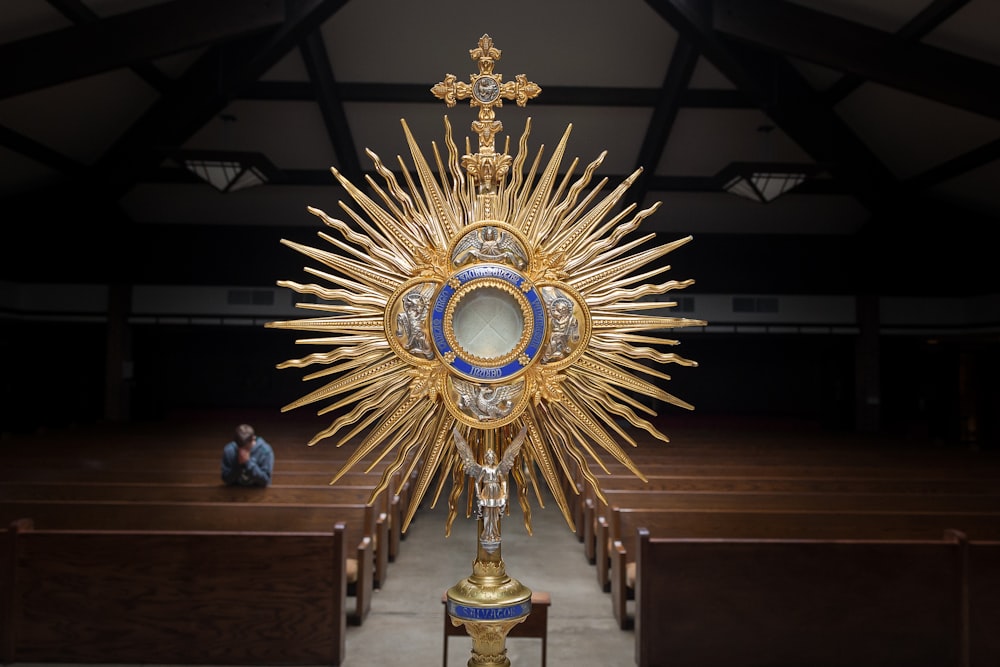 gold-colored cross table decor on top of brown wooden table