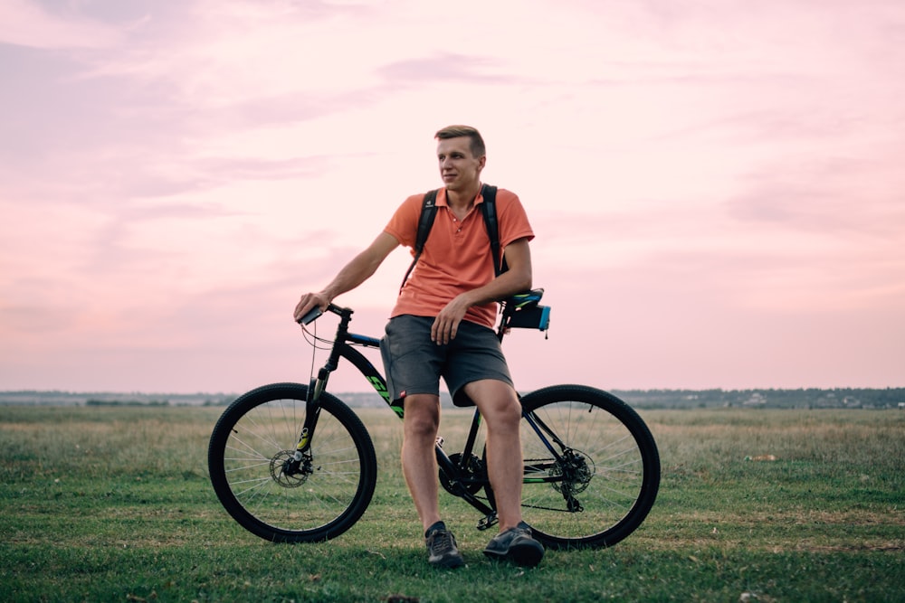 Mann sitzt auf Hardtail-Bike unter goldener Stunde