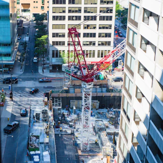 A bustling construction site with workers handling heavy machinery and materials, showcasing active project work.