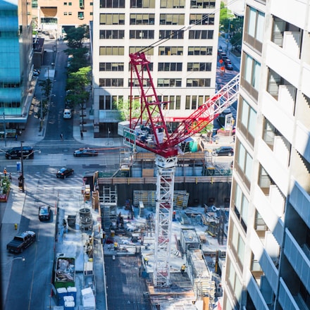 A bustling construction site showcasing cranes and workers collaborating on a large urban infrastructure project.