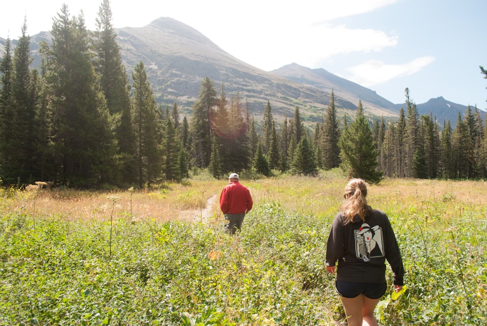 Femme en T-shirt noir debout sur un terrain d’herbe verte pendant la journée