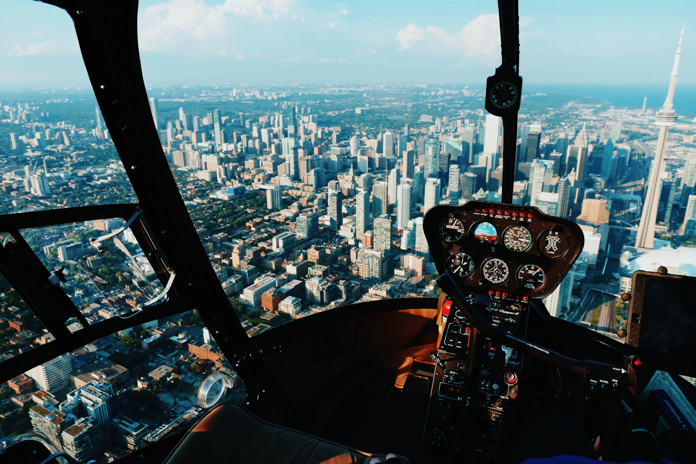 Helicopter pilot at the controls in the cockpit during a flight over water and coastline
