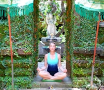 Sunil Chhaya in a serene outdoor space practicing meditation surrounded by lush greenery.