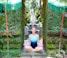 Image of a man meditating under lush trees inside the ashram.